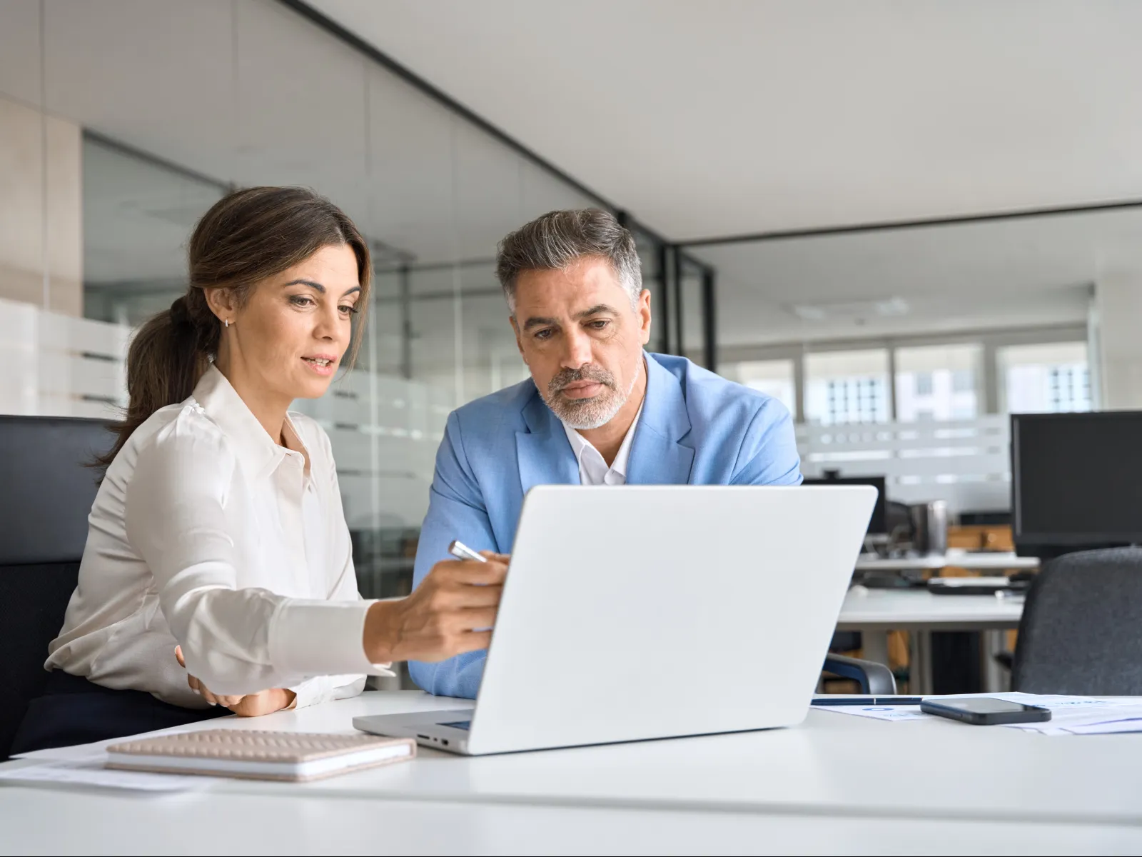 a man and a woman looking at a laptop