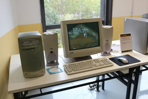 An out of date desktop computer setup with CRT monitor, tower, speakers, keyboard, and mouse on a white table